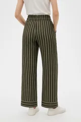 Pantalón ancho color beige con rayas verticales blancas, cintura alta con cordón ajustable y bolsillos laterales.