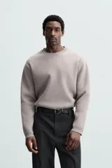Sweater negro de punto con cuello redondo y mangas largas.