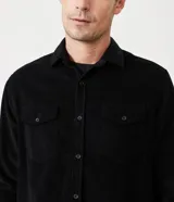 Camisa blanca de manga larga, confeccionada en terciopelo con cuello clásico y bolsillos frontales.