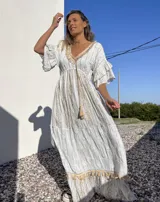 Vestido túnica largo de color celeste con bordados dorados y detalles de encaje en el escote y ruedo.