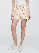 Short deportivo de felpa color crema con estampado floral multicolor y logo GAP bordado en rojo.
