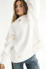 Buzo blanco de felpa de algodón con pespuntes en zigzag color naranja y logo bordado en el pecho.