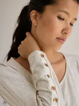 Remera blanca de algodón con escote redondo, mangas largas y pespuntes verticales a contratono.