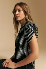 Remera de manga corta con rayas horizontales negras y blancas. Presenta cuello redondo y mangas abullonadas con frunce en los hombros.