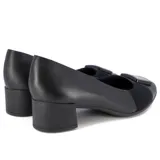 Zapato de cuero negro con taco cuadrado bajo, detalle de elástico y aplique metálico en el empeine.