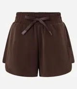 Bermuda deportiva femenina color marrón chocolate, modelo runner, con cintura elástica ajustable con lazo, bolsillos laterales y aberturas laterales.