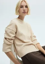 Sweater color beige de tejido de punto con cuello redondo y mangas largas.