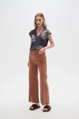Pantalón de jean color beige, de corte flare y tiro alto, con terminación desflecada.