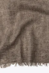 Pañuelo rectangular color marrón oscuro, confeccionado en tejido rústico con lana y terminaciones deshilachadas.