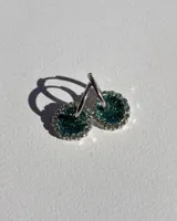 Aritos colgantes con dije circular de resina color verde esmeralda con glitter y strass plateados. El arito es de acero quirúrgico.