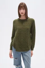 Sweater de algodón color verde oliva con textura de punto en zigzag y motas de colores. Presenta cuello redondo y mangas largas tipo ranglán, con calce holgado.