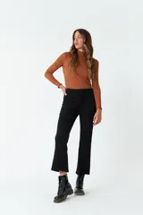 Pantalón de pana negro, de corte recto y tiro medio, con bolsillos y presillas para cinturón.