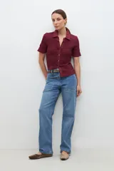 Camisa de punto smock color burdeos, con manga corta y botones frontales.