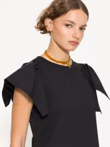 Top color naranja con cuello redondo y mangas cortas con volados.