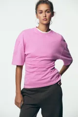 Camiseta rosa entallada de algodón con cuello redondo y mangas cortas.