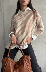 Sweater beige con estampado de cebra en color rosa, cuello redondo y corte holgado.