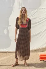 Vestido largo de viscosa estampada con escote en V y mangas cortas. Presenta bordados en el delantero y en la espalda, mangas con frunces en la copa y elástico en los puños, cintura con elástico y cierre con gancho invisible en el lateral.