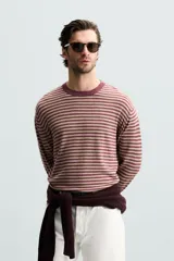 Jersey de hombre de corte regular, con cuello redondo y manga larga. Diseño a rayas horizontales en color borgoña y beige.