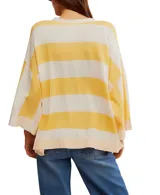 Remera de corte extragrande a rayas horizontales amarillas y blancas, confeccionada en jersey de peso medio, con textura suave y hombros caídos para un look relajado. Presenta un cierre frontal parcial con botón y terminaciones simples.