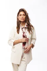 Blazer color crema con solapas de muesca, corte recto, bolsillos delanteros con solapa y mangas 3/4 con botón.