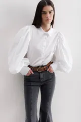 Camisa color beige de algodón con mangas abullonadas y cierre con botones.