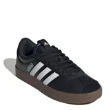 Championes urbanos Adidas modelo VL Court 3.0, color negro con tres franjas laterales blancas. Poseen capellada de cuero sintético texturizado, puntera reforzada y suela vulcanizada de caucho color marrón.