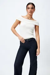 Pantalón de jean azul oscuro, de corte flare con cinturón incorporado en la misma tela y silueta ajustada en cadera que se ensancha hacia el ruedo.