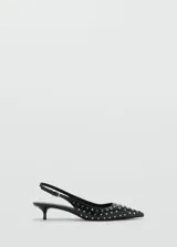 Zapato destalonado negro con tachas plateadas, punta fina, tacón kitten y tira trasera ajustable.