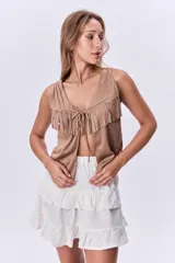 Chaleco color visón con flecos en el pecho y corte en V.