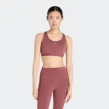 Top deportivo New Balance Essential Run Bra color borgoña, con logo plateado en el frente, espalda deportiva y breteles regulables.