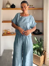 Pantalón ancho de tiro alto, color beige claro con textura, confeccionado en tela crepé. Presenta cintura elástica con cordón ajustable.