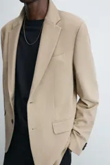 Blazer straight fit color gris confeccionada en tejido con viscosa. Cuello con solapas de muesca y manga larga acabada en puño con botón. Bolsillo de vivo en pecho y bolsillos de plastrón en cadera. Bajo con aberturas en espalda. Cierre frontal de botonadura.