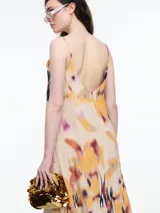 Vestido largo de breteles finos confeccionado en viscosa crinkled con estampa de manchas. De escote en V y silueta evasé, tiene una caída fluida que acompaña el movimiento. El efecto arrugado del tejido le da textura y carácter a una prenda fresca y versátil.