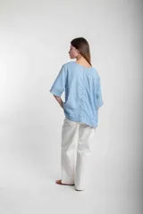 Blusa de lino negra de corte suelto, con mangas anchas y detalle sencillo en el escote.