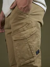 Pantalón cargo color marrón con bolsillos laterales con solapa y corte ajustado.