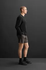 Shorts deportivos color gris oscuro confeccionados en tejido técnico ligero y elástico con forro interior, cintura elástica ajustable con cordón, bolsillos laterales, bolsillo de seguridad en espalda con cierre de cremallera, bajo con aberturas laterales y detalle de logo estampado en pernera.