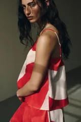 Top blanco con estampado de círculos rojos, escote redondo, breteles finos y corte evasé.