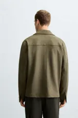 Sobrecamisa color beige de tejido efecto ante, corte regular fit, con cuello solapa, manga larga con puños abotonados, bolsillos de parche con solapa en el pecho y bolsillos de ojal en la cadera.