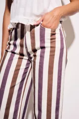 Pantalón de jean de corte wide leg, tiro medio, con rayas verticales en tonos marrón, morado y blanco crema.