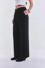 Pantalón negro de lino, de corte amplio, con pretina de botón y cierre. No tiene lycra.