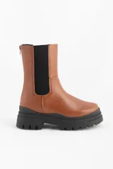 Bota media caña color marrón con elástico lateral y suela track.