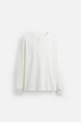 Camiseta blanca de waffle con cuello redondo y cierre frontal de botonadura. Manga larga acabada en rib.
