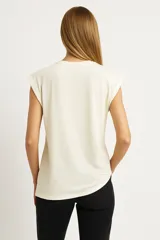 Remera blanca de algodón con mangas cortas, cuello redondo y estampado con imágenes de cartas de tarot y texto en negro.