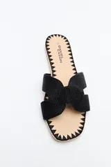 Sandalia baja negra con capellada trenzada tipo cordón, suela plana con bordado a tono.