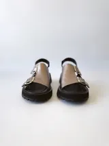 Sandalias de cuero color peltre con plataforma y suela track color negro. Presentan dos tiras anchas con hebillas plateadas y tira trasera ajustable.