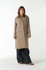 Tapado largo color beige confeccionado en lana, con cuello con solapa, manga larga, forrado, con bolsillos y cierre frontal con botones. Tela 100% lana fina sin teñir, diseñada exclusivamente por Don Baez. Hecho 100% en Uruguay.