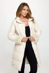 Campera puffer larga color crema con cuello de piel sintética, cierre con botones a presión y puños de piel sintética.
