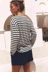 Camiseta de manga larga a rayas horizontales blancas y azules, de tejido rústico tipo punto y cuello redondo.