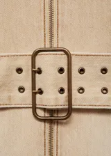 Vestido corto color beige, con cuello halter, cierre frontal con cremallera y cinturón con hebilla.