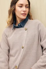 Sweater tejido color verde oliva con cruce irregular y botones a contraste.